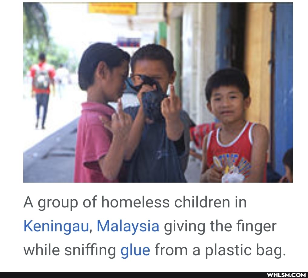 A group of homeless children in
Keningau, Malaysia giving the finger while sniffing glue from a plastic bag.