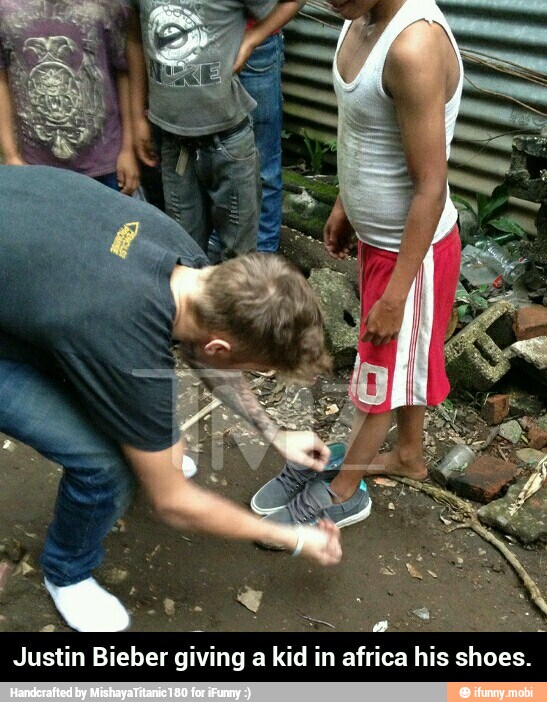 Justin Bieber giving a kid in africa his shoes. - Justin Bieber giving a kid in africa his shoes.