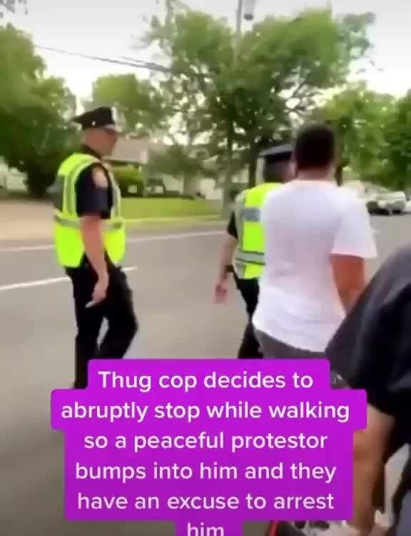 Thug cop decides to abruptly stop while walking so a peaceful protestor